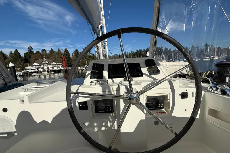 "lagu" Yacht Photos Pics Steering wheel of a 2012 Lagoon 450 catamaran docked in a scenic marina.