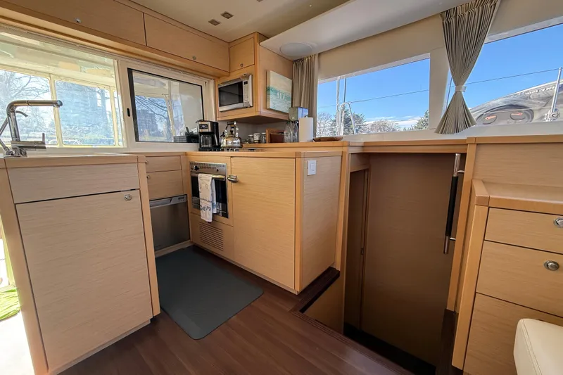 "lagu" Yacht Photos Pics Modern kitchen interior of 2012 Lagoon 450 catamaran with wood cabinetry and appliances.