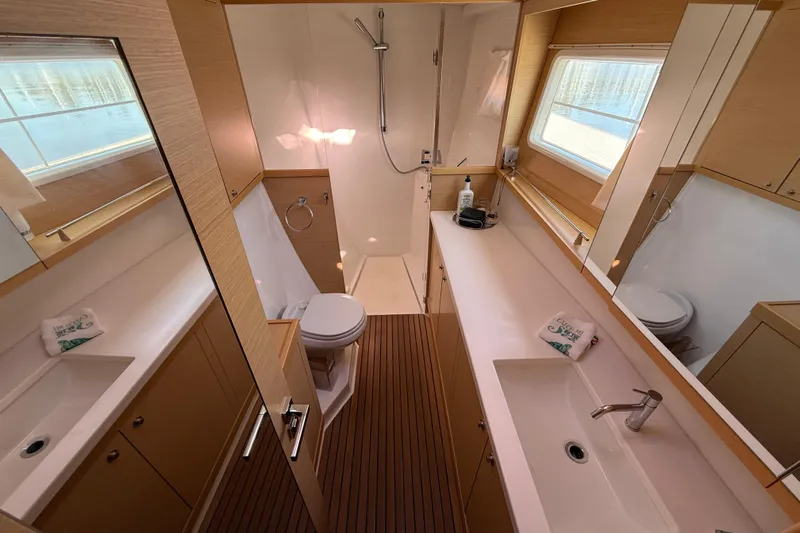 "lagu" Yacht Photos Pics Luxurious bathroom in a 2012 Lagoon 450 yacht, featuring modern fixtures and wooden accents.