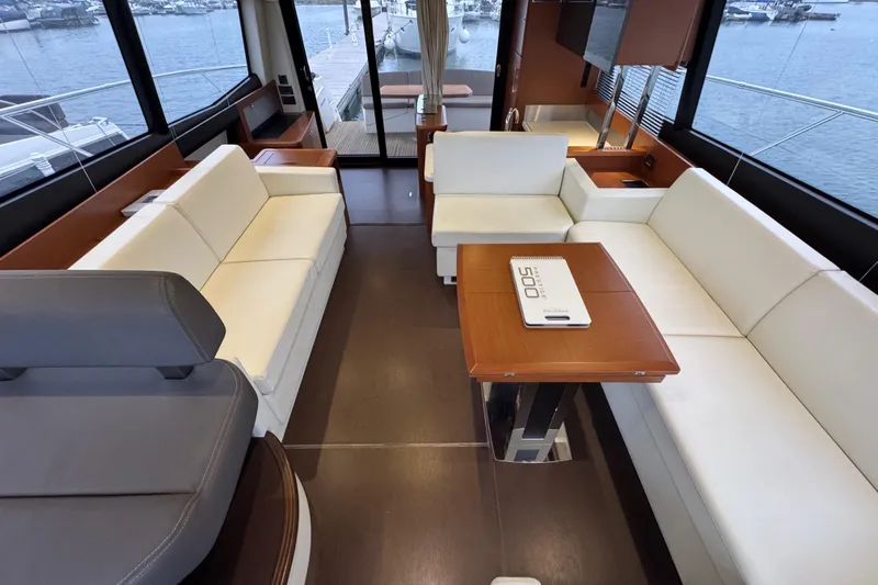  Yacht Photos Pics Luxurious interior of 2013 Prestige 500 yacht with elegant seating and table, overlooking marina.