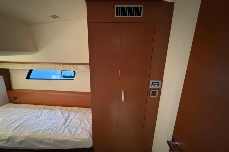  Yacht Photos Pics Interior cabin of 2013 Prestige 500 yacht with bed and wooden cabinetry.