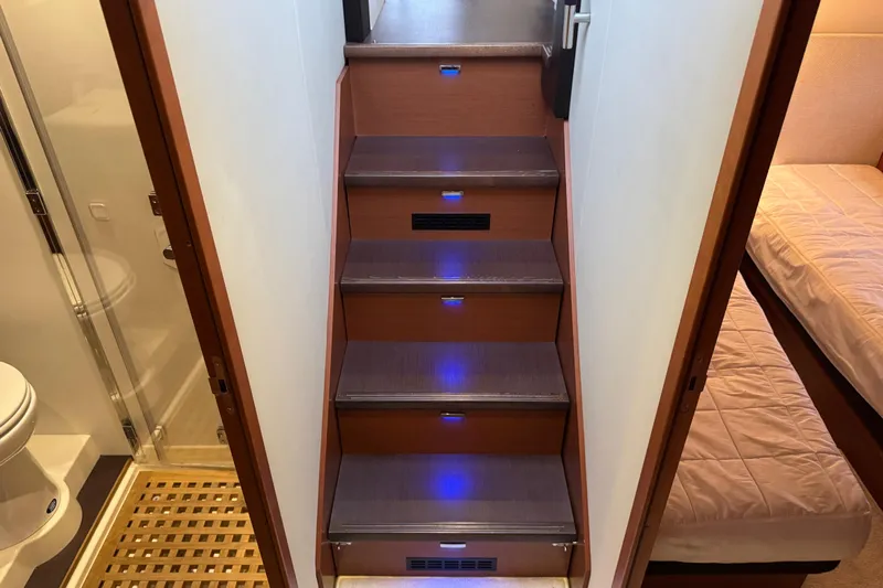  Yacht Photos Pics Interior of 2013 Prestige 500 yacht with illuminated wooden stairs and adjacent bathroom.