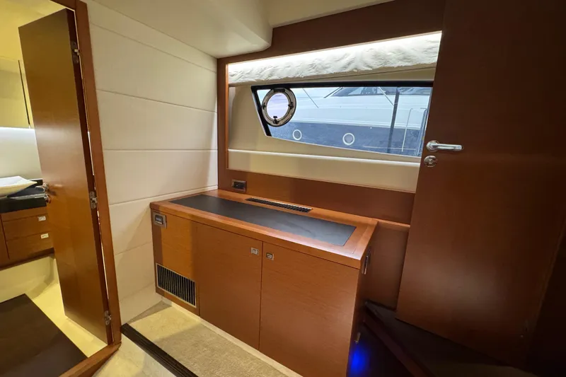  Yacht Photos Pics Luxurious interior of 2013 Prestige 500 yacht with wooden cabinetry and porthole window.