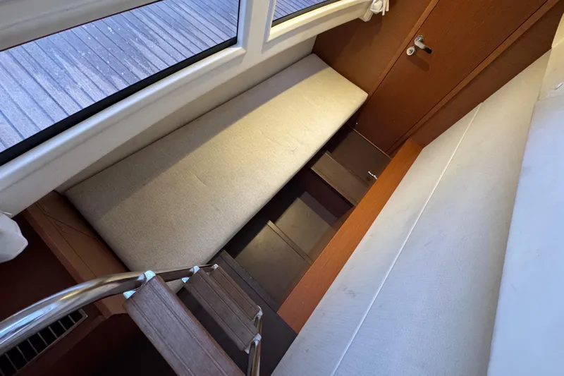  Yacht Photos Pics Interior of 2013 Prestige 500 yacht with wooden stairs and cushioned seating.