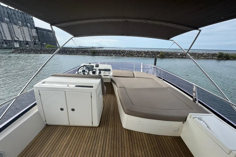  Yacht Photos Pics 2013 Prestige 500 yacht deck with seating and helm, docked by a stone wall.