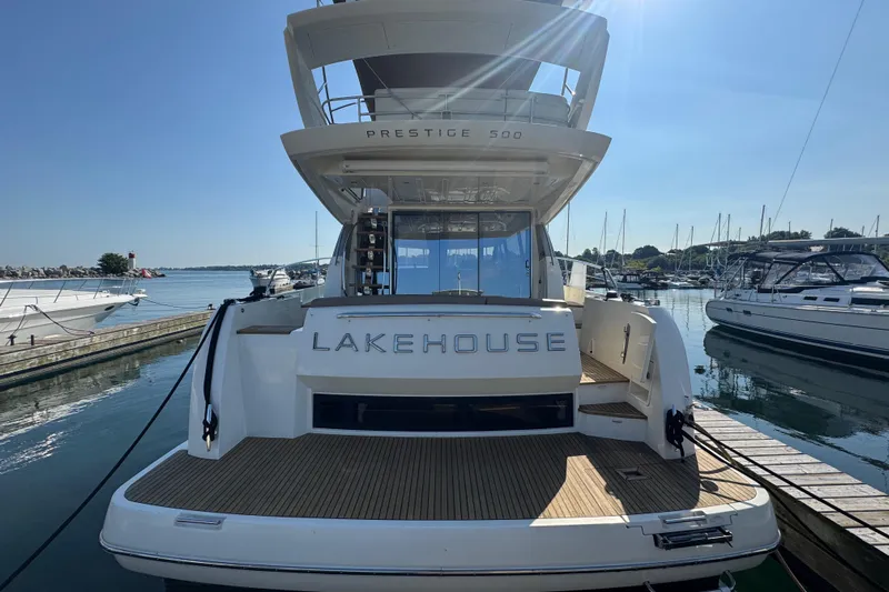  Yacht Photos Pics 2013 Prestige 500 yacht "Lakehouse" docked at marina under clear blue sky.