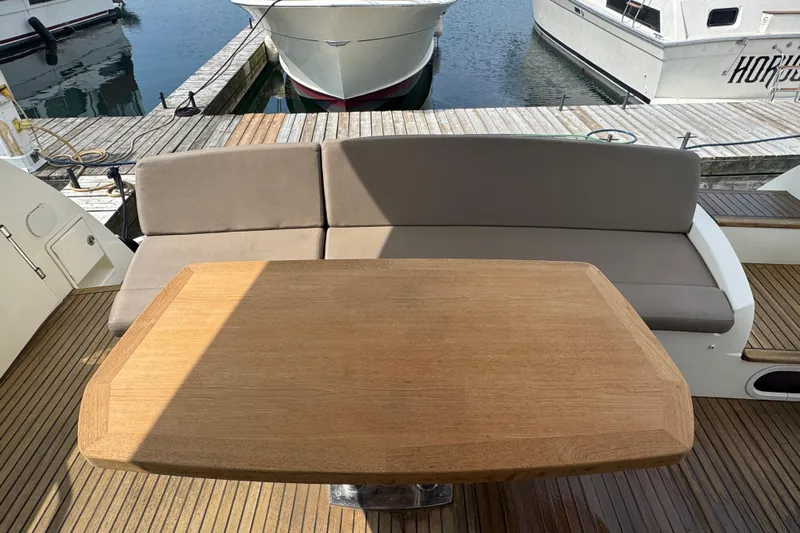  Yacht Photos Pics Luxury yacht deck with wooden table and cushioned seating, Prestige 500, 2013 model.