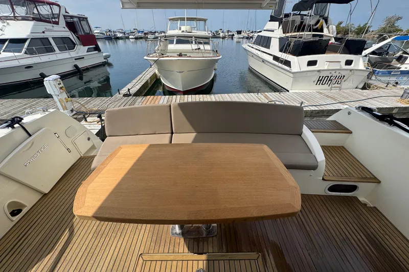  Yacht Photos Pics Luxurious 2013 Prestige 500 yacht interior with wooden table and seating at marina.