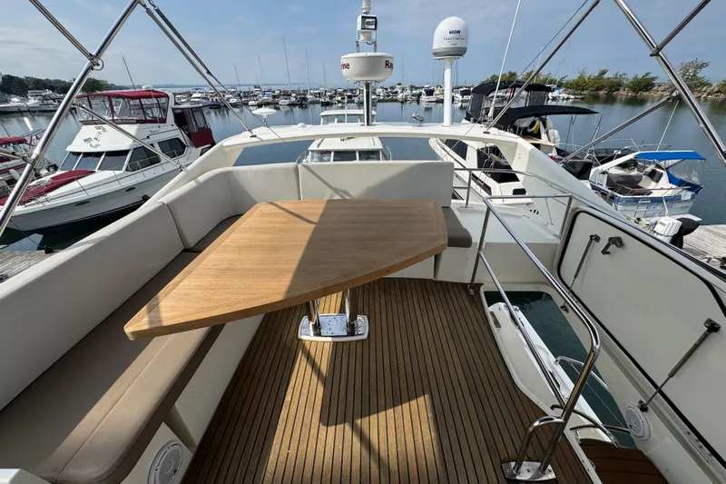  Yacht Photos Pics Flybridge of 2013 Prestige 500 yacht with wooden table, docked at marina.