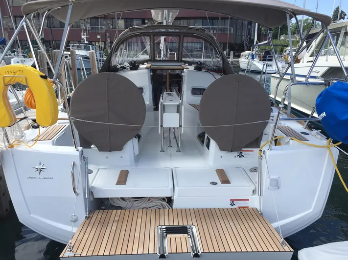 Venteux Yacht Photos Pics 2016 Jeanneau Sun Odyssey 349 sailboat with covered steering wheels, docked at a marina.
