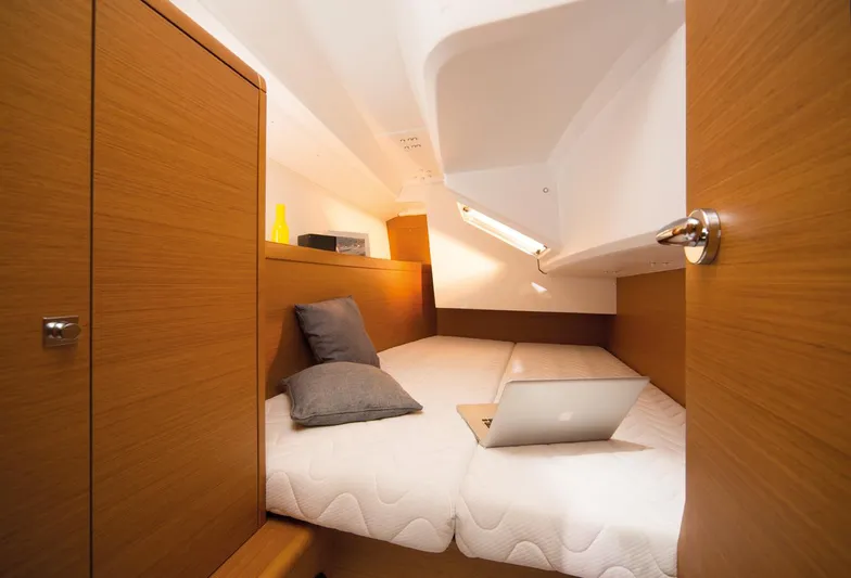 Venteux Yacht Photos Pics Cozy cabin interior of 2016 Jeanneau Sun Odyssey 349 sailboat with bed and laptop.