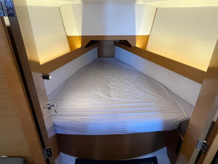 Venteux Yacht Photos Pics 2016 Jeanneau Sun Odyssey 349 cabin with cozy bed and wooden accents.
