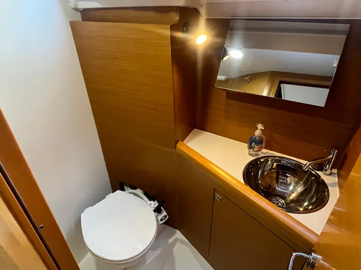 Venteux Yacht Photos Pics Bathroom interior of 2016 Jeanneau Sun Odyssey 349 yacht with sink, mirror, and toilet.