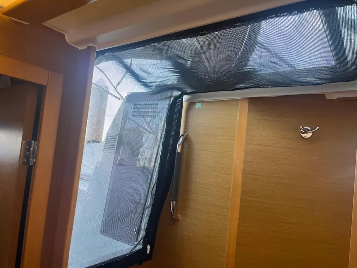 Venteux Yacht Photos Pics Interior view of 2016 Jeanneau Sun Odyssey 349 sailboat with wooden finish and mesh window.