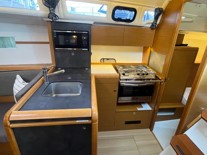 Venteux Yacht Photos Pics Modern kitchen in 2016 Jeanneau Sun Odyssey 349 yacht with stove, sink, and microwave.