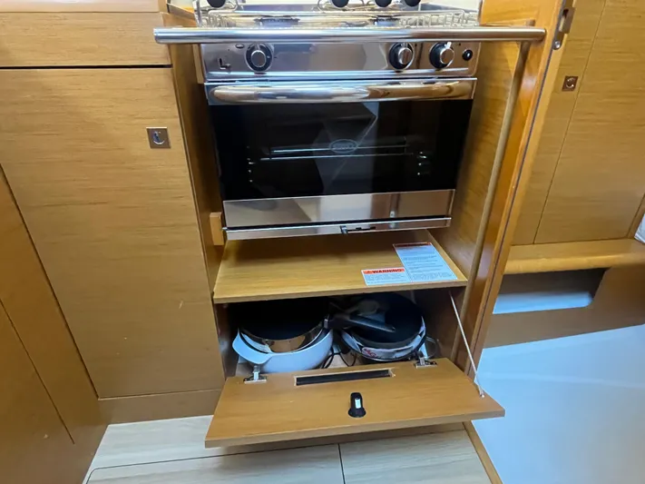 Venteux Yacht Photos Pics Compact kitchen area in a 2016 Jeanneau Sun Odyssey 349 sailboat, featuring a stove and storage.