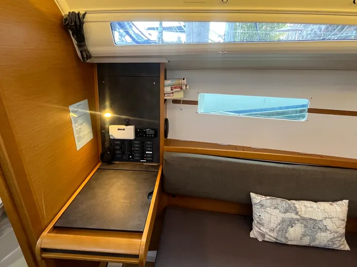 Venteux Yacht Photos Pics Interior of 2016 Jeanneau Sun Odyssey 349 sailboat with navigation station and map-themed pillow.