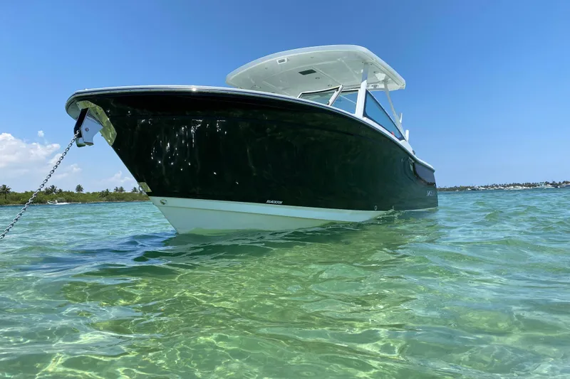  Yacht Photos Pics 2022 Blackfin 272DC boat anchored in clear turquoise water under a blue sky.