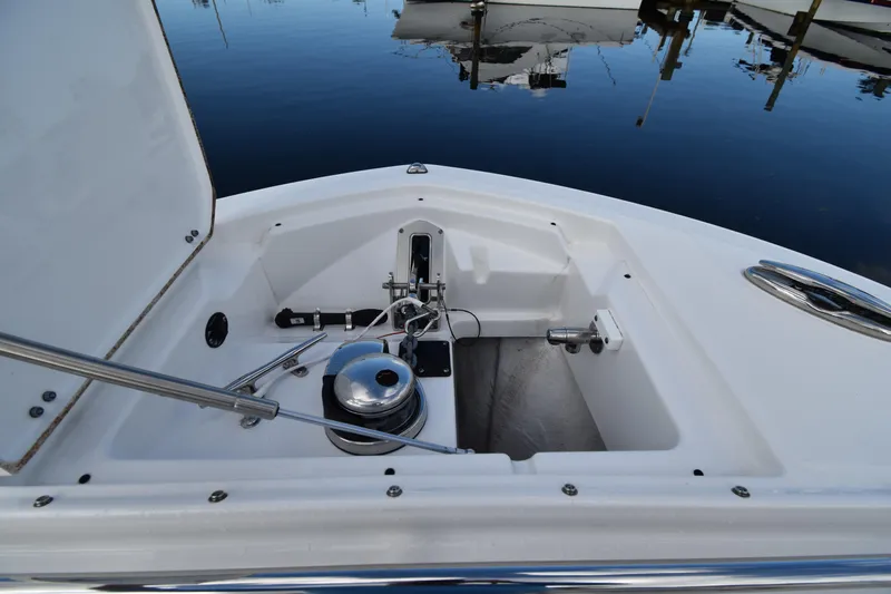 Yacht Photos Pics 2022 Blackfin 272DC boat anchor compartment with winch, docked on calm water.