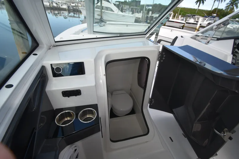  Yacht Photos Pics 2022 Blackfin 272DC boat interior with compact marine toilet and cup holders.