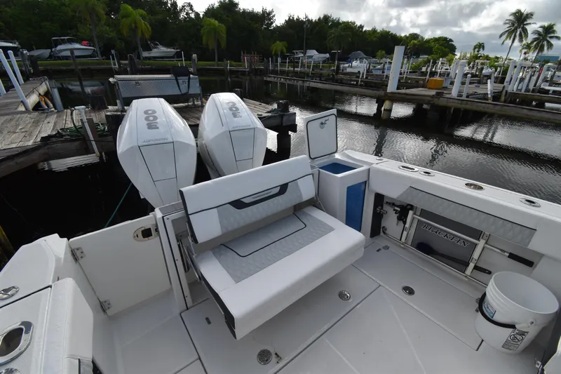  Yacht Photos Pics 2022 Blackfin 272DC boat with dual outboard engines docked at a marina.