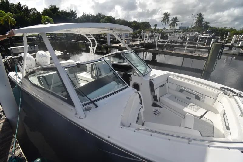  Yacht Photos Pics 2022 Blackfin 272DC boat docked, featuring sleek design and spacious seating.