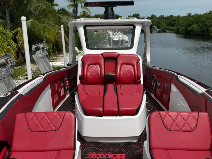  Yacht Photos Pics Luxurious 2022 Deep Impact 399 boat with red leather seating on a serene waterway.