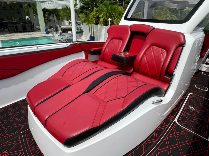  Yacht Photos Pics Luxurious red and black seating on 2022 Deep Impact 399 boat, near a poolside setting.