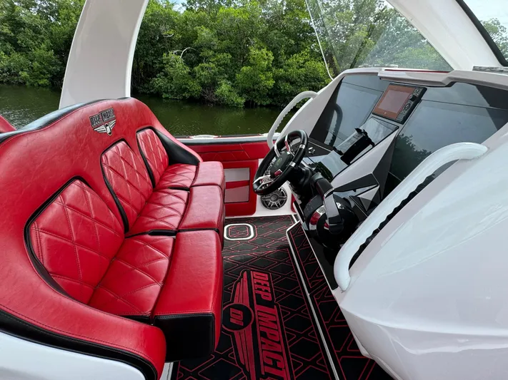  Yacht Photos Pics Luxurious 2022 Deep Impact 399 boat interior with red leather seats and modern dashboard.