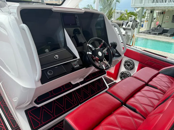  Yacht Photos Pics Luxurious 2022 Deep Impact 399 boat interior with red seating and modern dashboard.