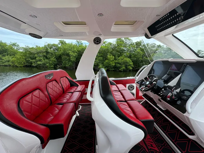  Yacht Photos Pics Luxurious 2022 Deep Impact 399 boat interior with red and black seating, modern dashboard.