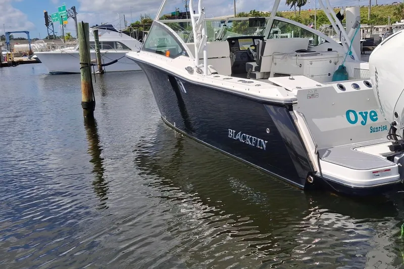  Yacht Photos Pics 2023 Blackfin 272DC boat docked in marina, featuring sleek design and modern amenities.