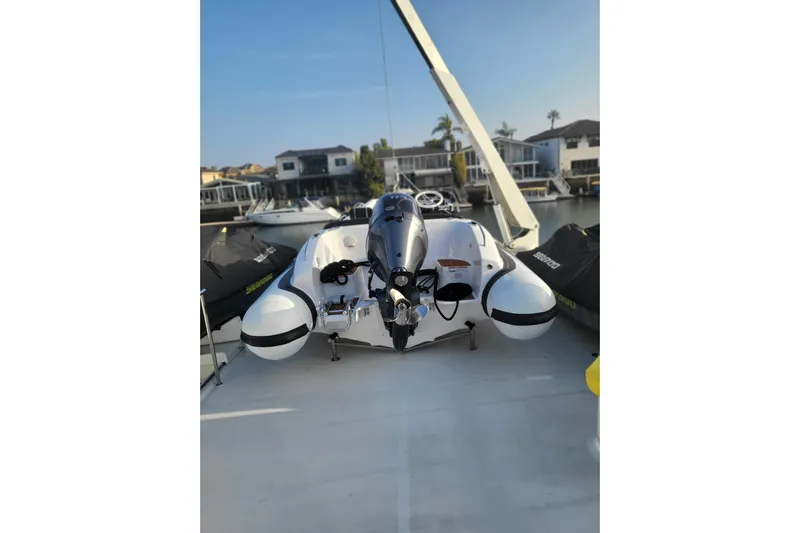 Lemonade Yacht Photos Pics Inflatable boat on deck of 2007 Cheoy Lee 100 yacht, docked near waterfront homes.