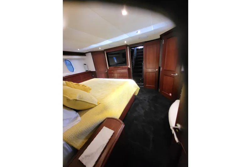 Lemonade Yacht Photos Pics Luxurious 2007 Cheoy Lee 100 yacht bedroom with yellow bedding and elegant wood finishes.