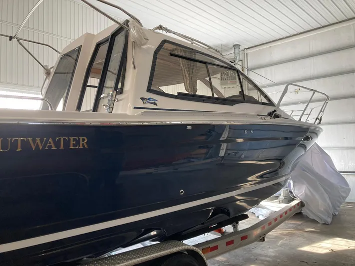  Yacht Photos Pics 2022 Cutwater C-24 Coupe boat in a garage, blue hull, on a trailer.