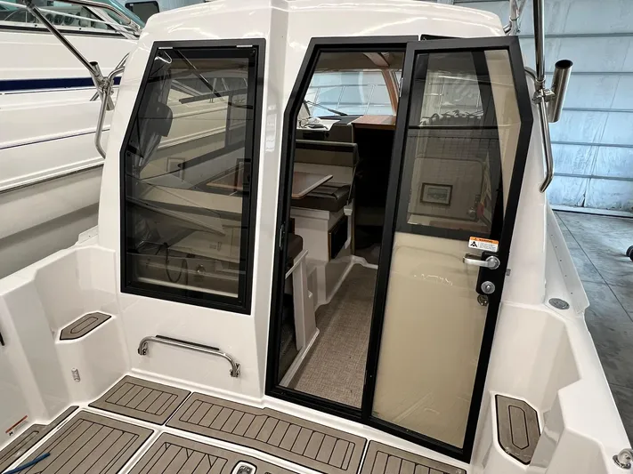  Yacht Photos Pics 2022 Cutwater C-24 Coupe boat interior with glass doors and teak flooring.