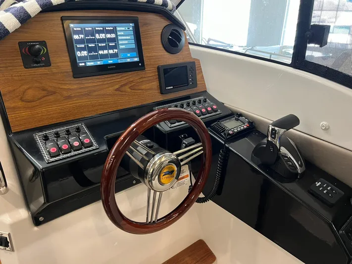  Yacht Photos Pics 2022 Cutwater C-24 Coupe helm with wood accents, digital display, and steering wheel.
