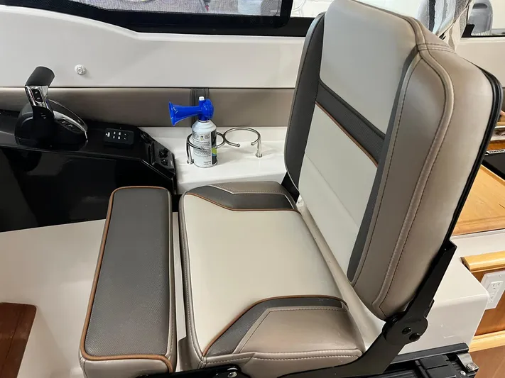  Yacht Photos Pics Captain's seat in 2022 Cutwater C-24 Coupe boat, featuring modern design and controls.