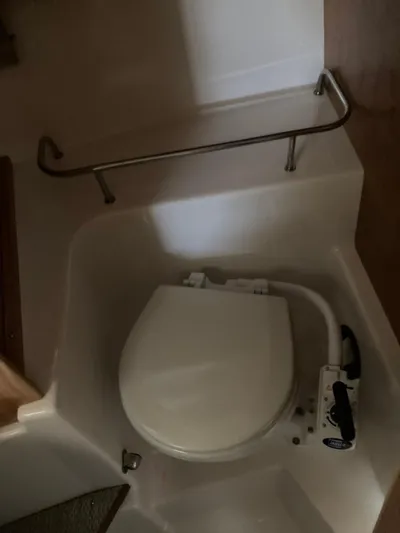  Yacht Photos Pics 2022 Cutwater C-24 Coupe boat bathroom with compact toilet and safety rail.