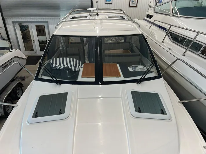  Yacht Photos Pics 2022 Cutwater C-24 Coupe boat in showroom, featuring sleek design and spacious cabin.