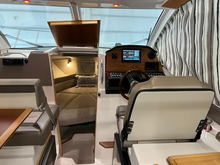  Yacht Photos Pics 2022 Cutwater C-24 Coupe interior with helm, seating, and cabin view.