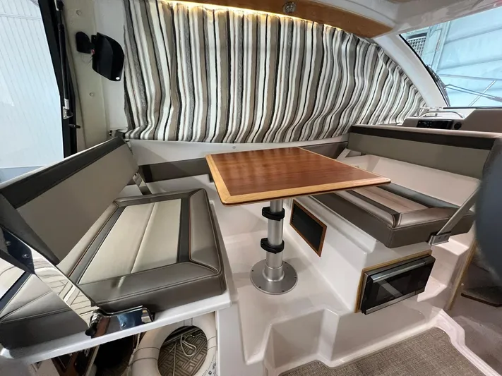  Yacht Photos Pics Interior of 2022 Cutwater C-24 Coupe with seating and wooden table.