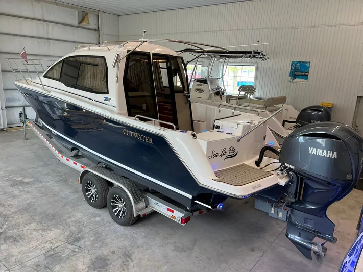  Yacht Photos Pics 2022 Cutwater C-24 Coupe boat with Yamaha engine on trailer in indoor storage.