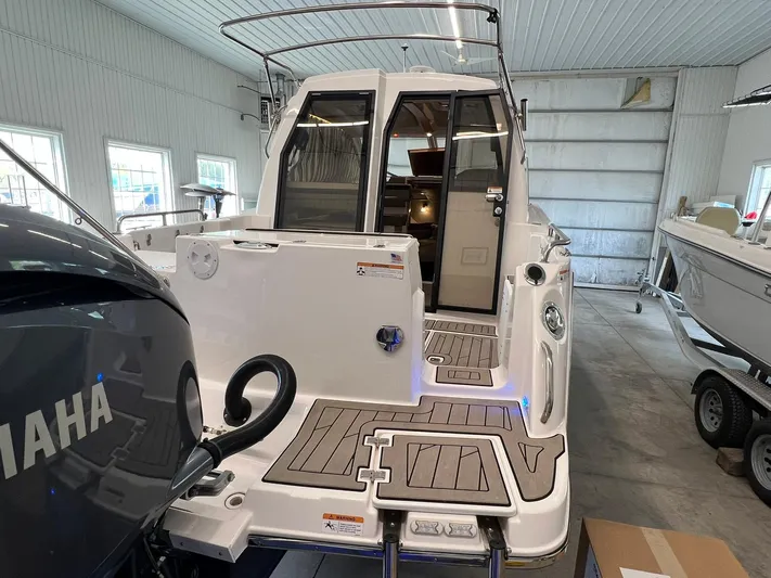  Yacht Photos Pics 2022 Cutwater C-24 Coupe boat in a garage, showcasing rear deck and interior view.