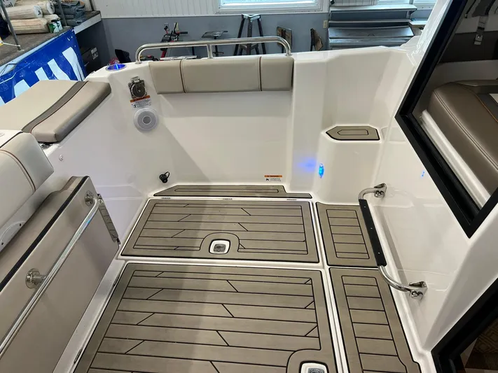  Yacht Photos Pics 2022 Cutwater C-24 Coupe boat interior with cushioned seating and wood-patterned flooring.