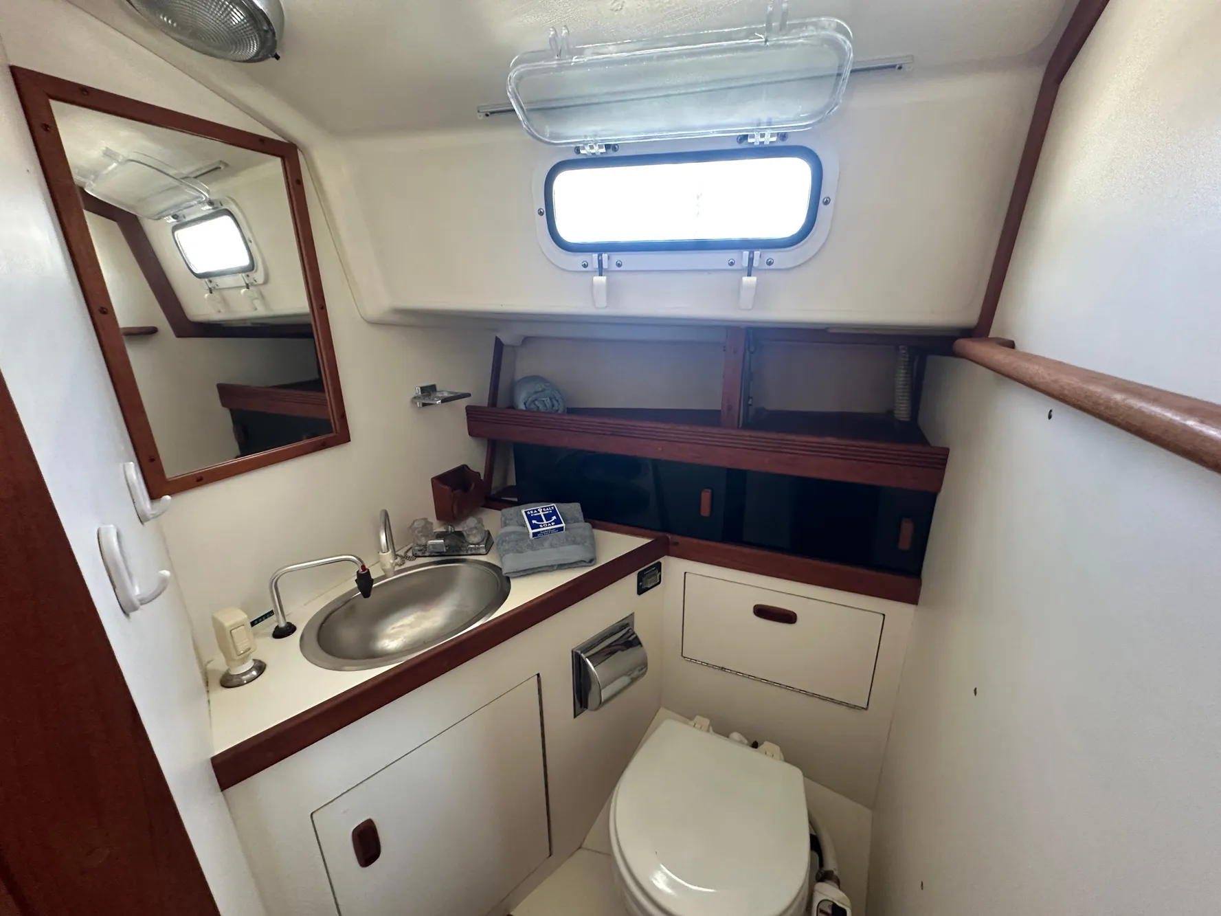 1985 Sabre 34 MKI yacht bathroom with sink, mirror, and porthole window.