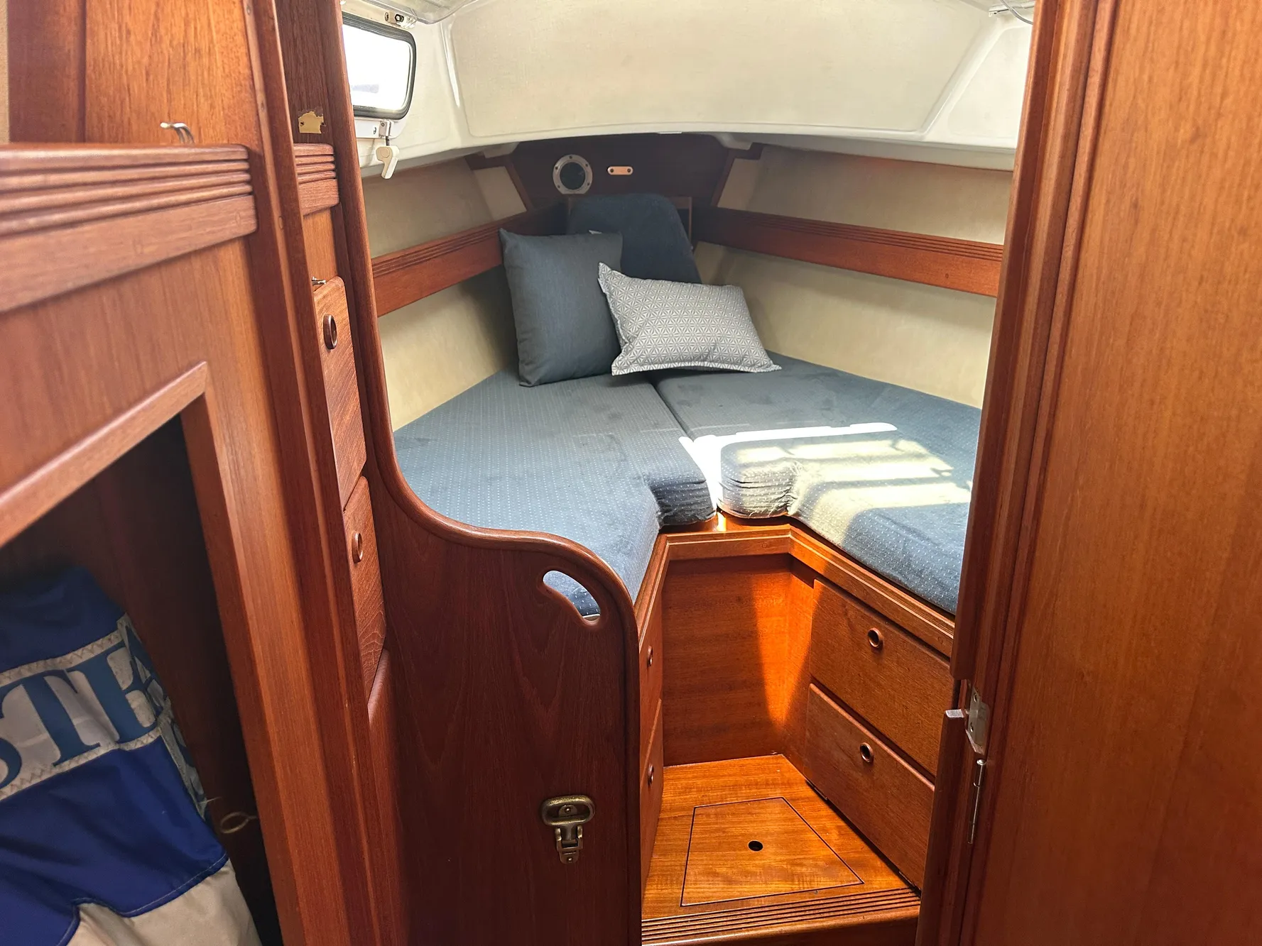 Cozy cabin interior of 1985 Sabre 34 MKI sailboat with wooden finish and blue bedding.