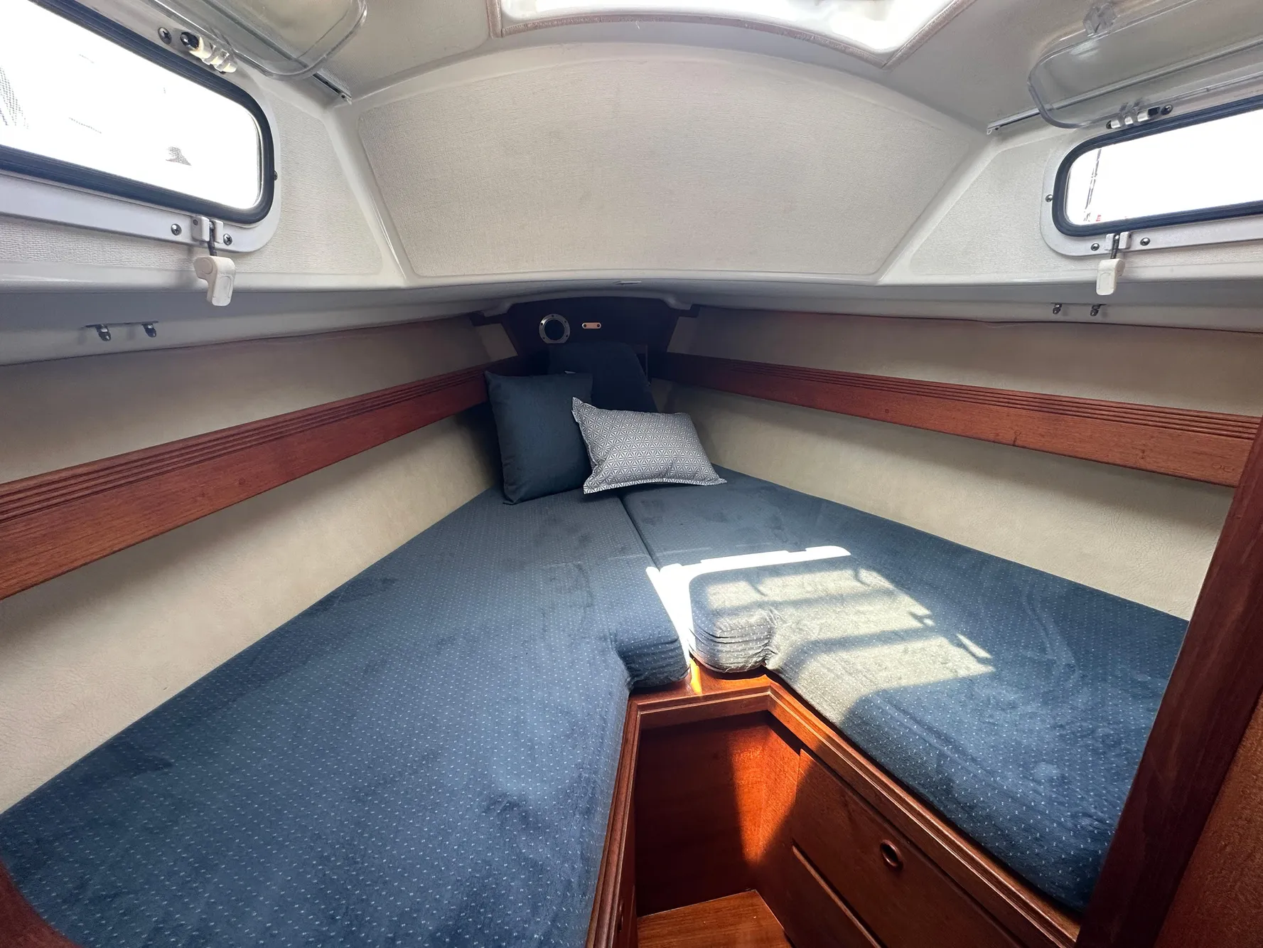 1985 Sabre 34 MKI sailboat cabin with cozy V-berth and blue bedding.