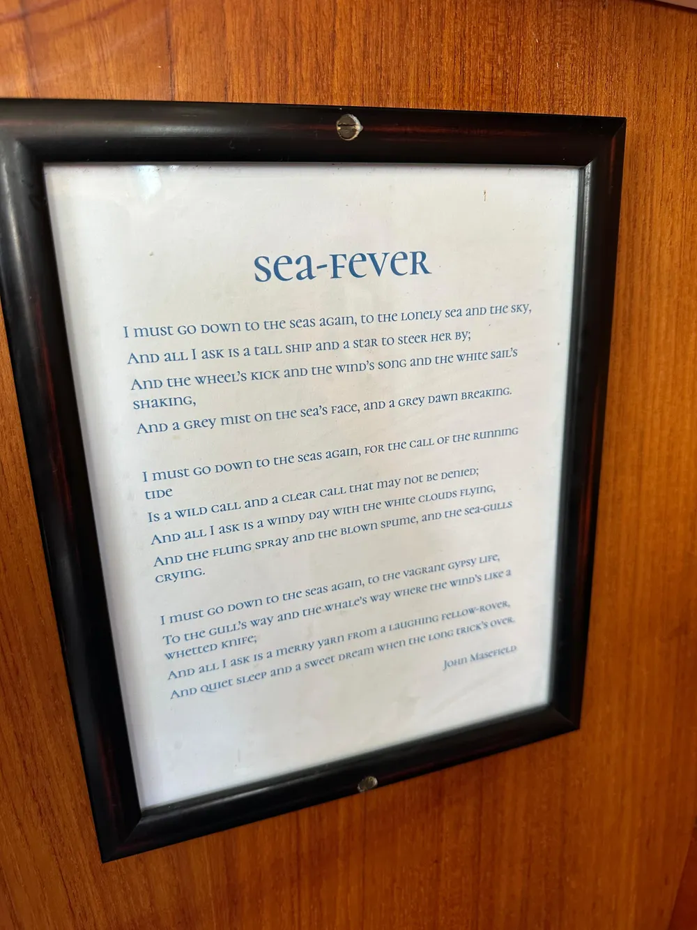 Framed "Sea-Fever" poem on Sabre 34 MKI sailboat, 1985 model, wooden background.