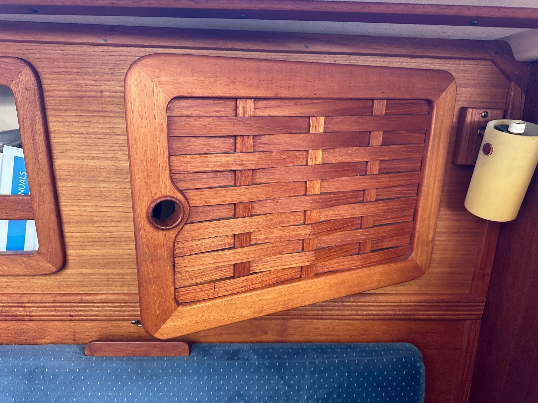 Wooden interior detail of a 1985 Sabre 34 MKI sailboat, featuring a woven cabinet door.